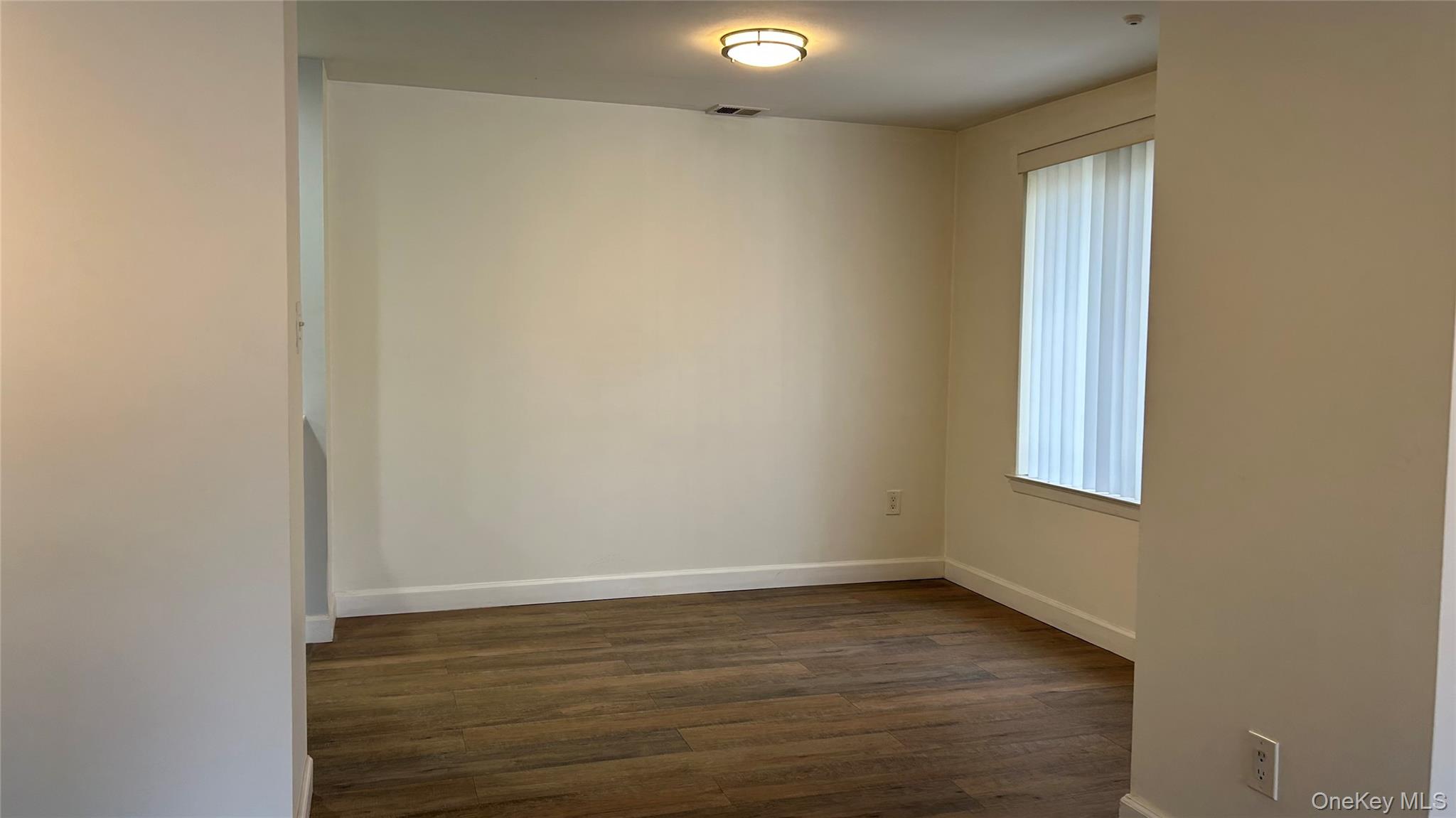 103 Birchwood Road, Unit 103 Medford, NY 11763 - Photo 8 of 13 a view of an empty room with wooden floor and a window