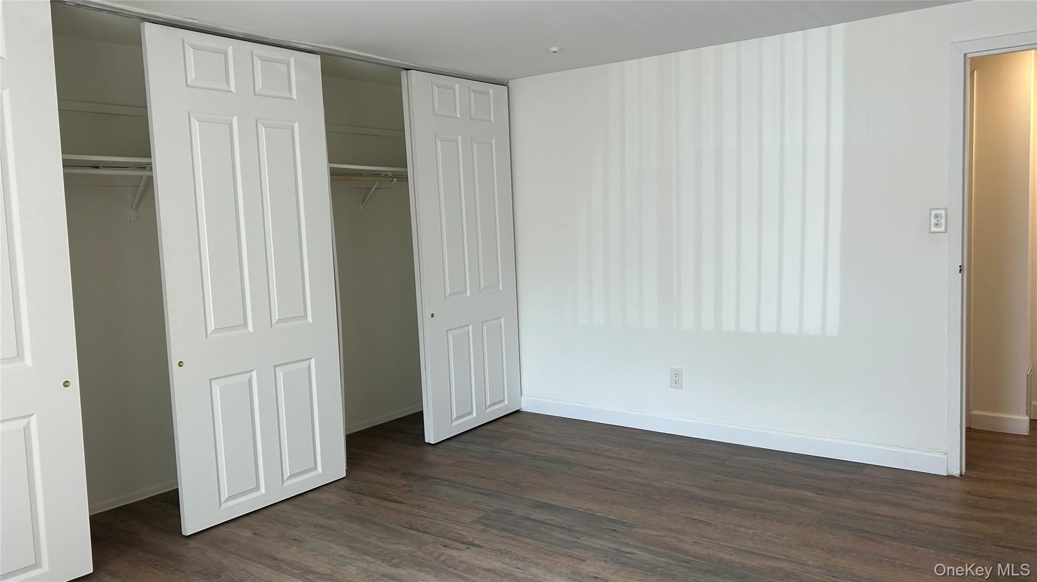 103 Birchwood Road, Unit 103 Medford, NY 11763 - Photo 10 of 13 an empty room with wooden floor and closet area