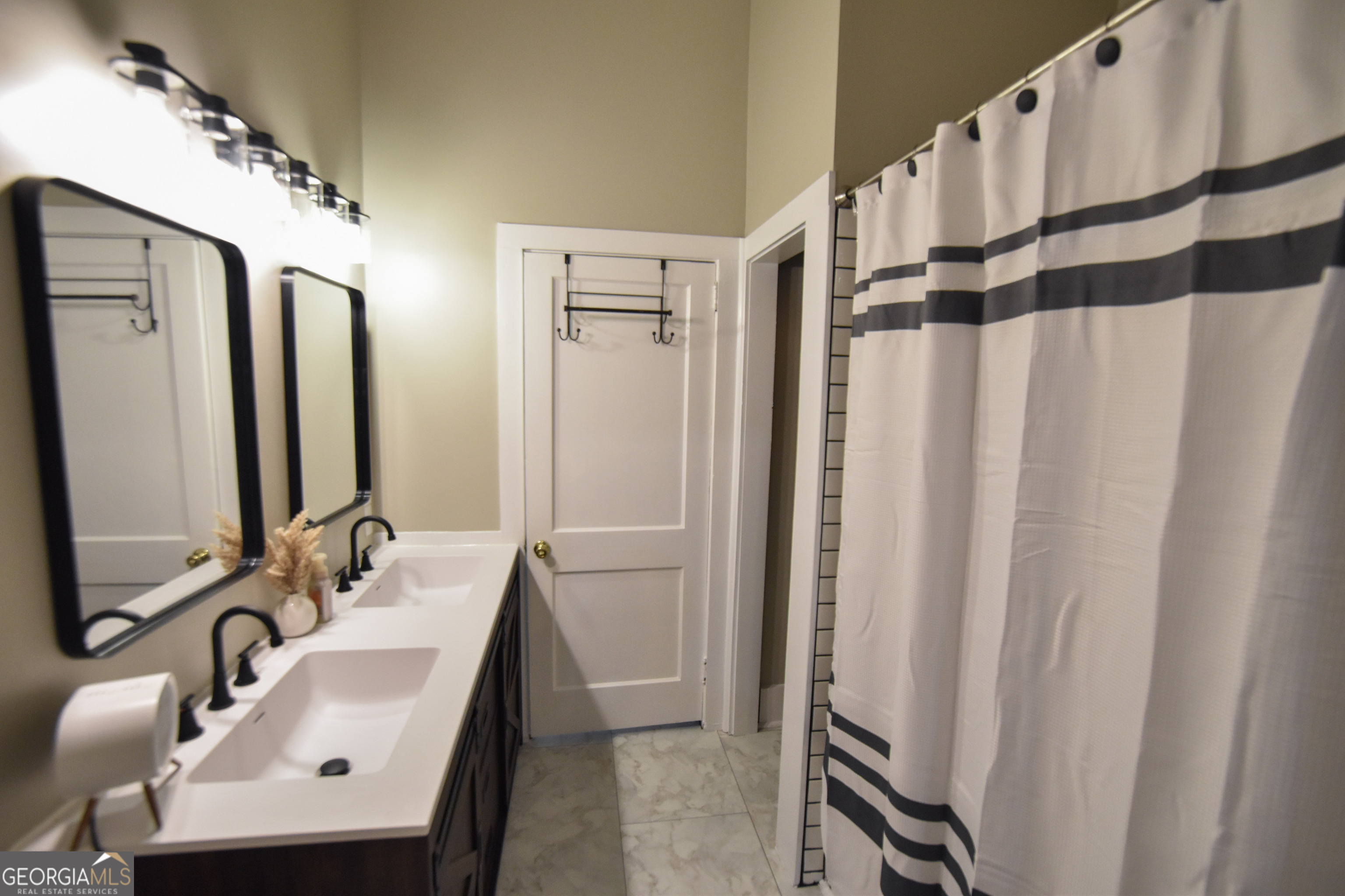 802 Mulberry Street Louisville, GA 30434 - Photo 22 of 51 a bathroom with a sink a mirror a shower and a mirror