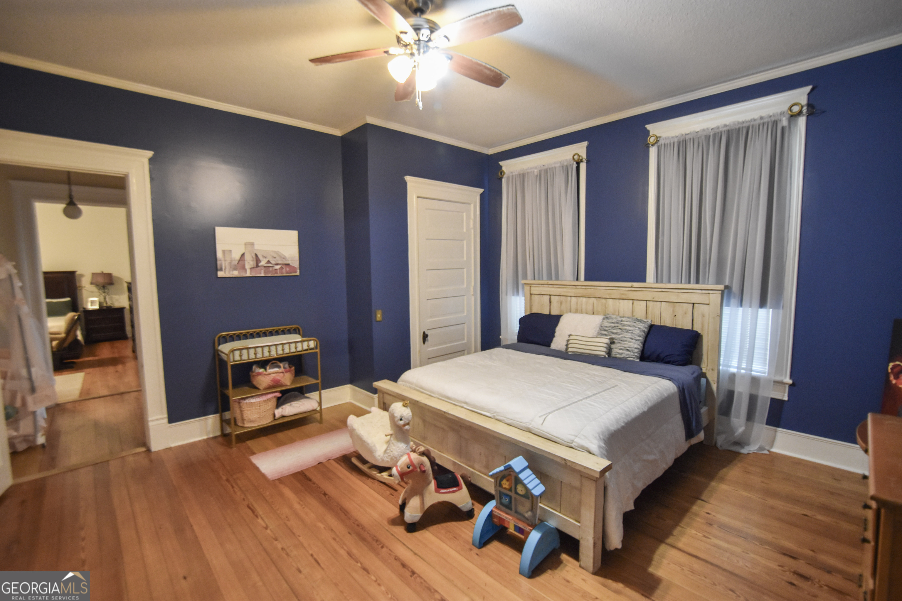 802 Mulberry Street Louisville, GA 30434 - Photo 24 of 51 a bedroom with a bed and a chandelier