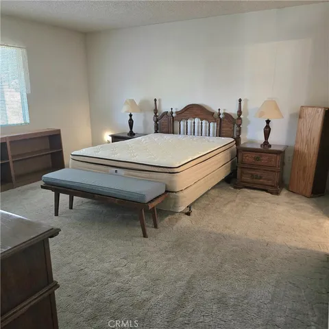 a bedroom with a bed and a mirror on dresser