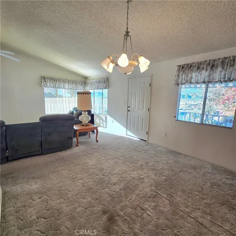 a room with chandelier fan and windows