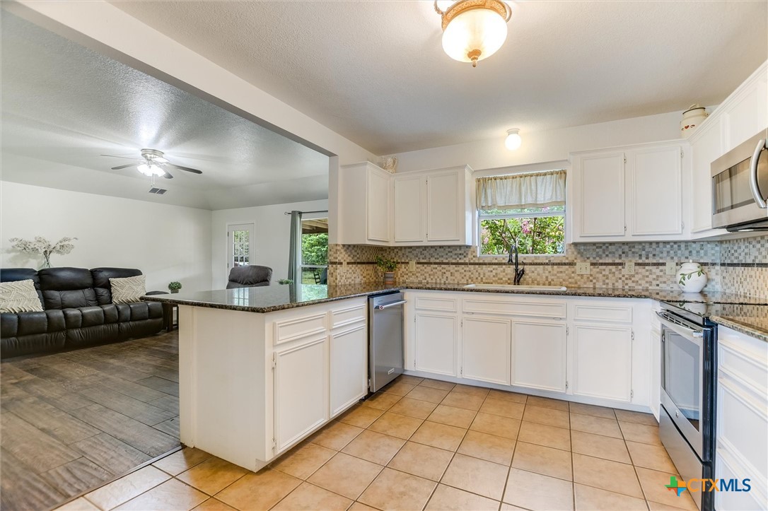 60 Crazy Cross Road Wimberley, TX 78676 - Photo 8 of 20 Kitchen boasts granite countertops and an open layout to the living space.