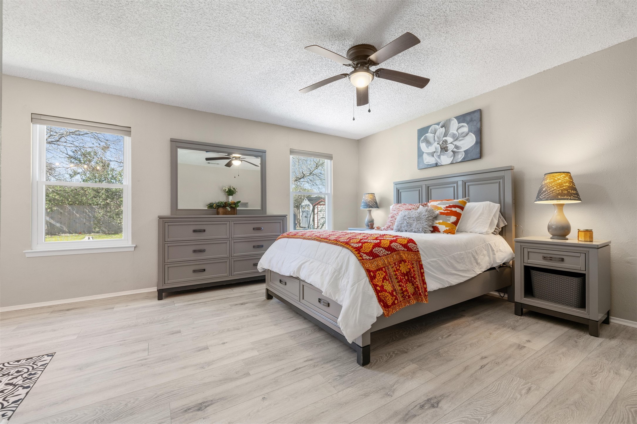 11302 Windermere Meadows Austin, TX 78759 - Photo 10 of 26 a bedroom with a large bed a chandelier and dresser