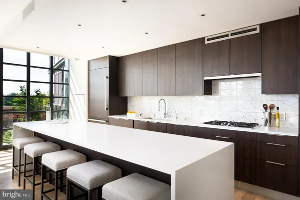 a kitchen with a sink a stove and chairs