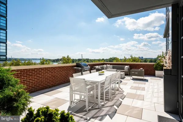 a view of a roof deck with couches and wooden floor