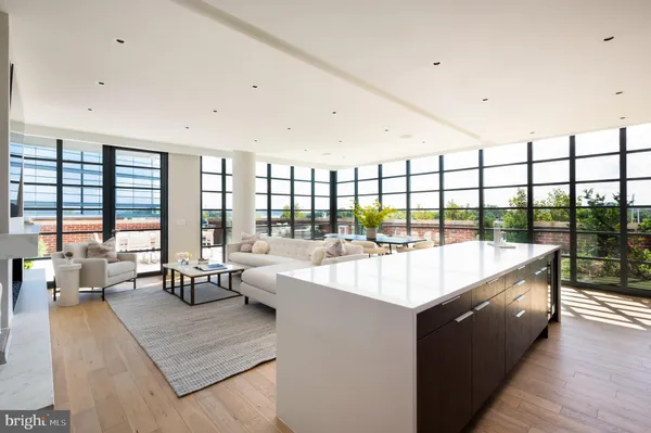a large white kitchen with a large window and couch