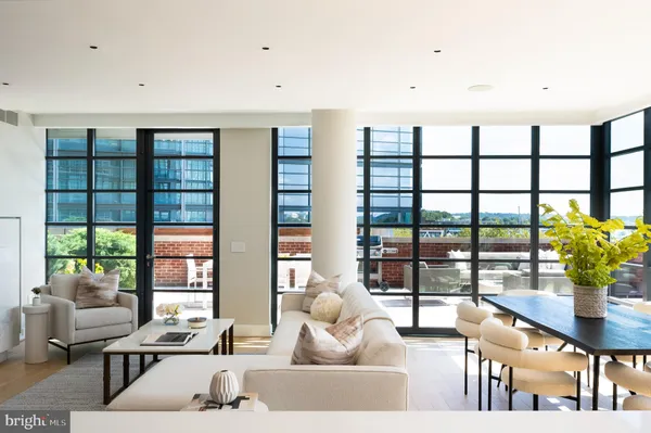 a living room with furniture and large windows