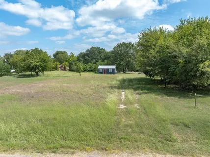a view of a field with trees in the background