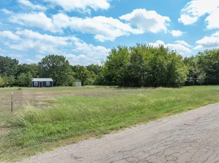 a view of a green field with wooden fence