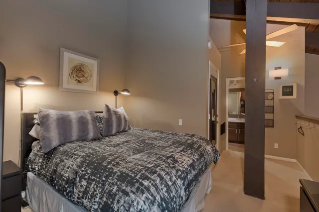 a bedroom with a large bed and a chandelier