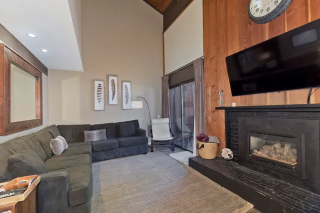 a living room with furniture a flat screen tv and a fireplace