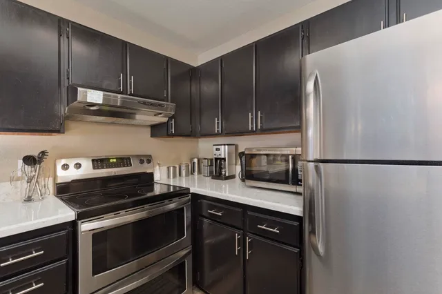 a kitchen with stainless steel appliances and wood cabinets