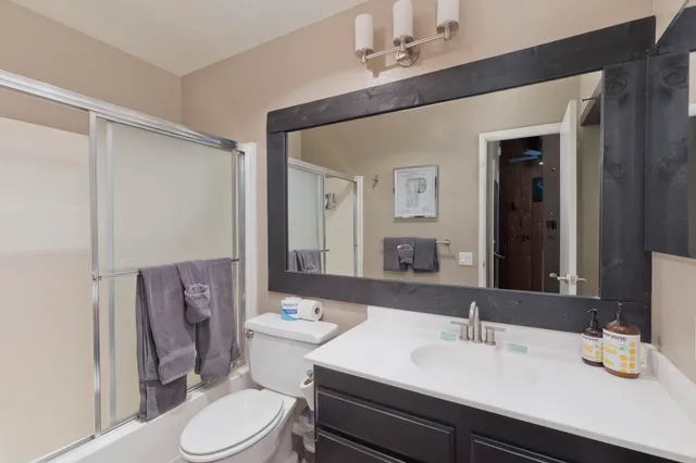 a bathroom with a sink a toilet a mirror and vanity