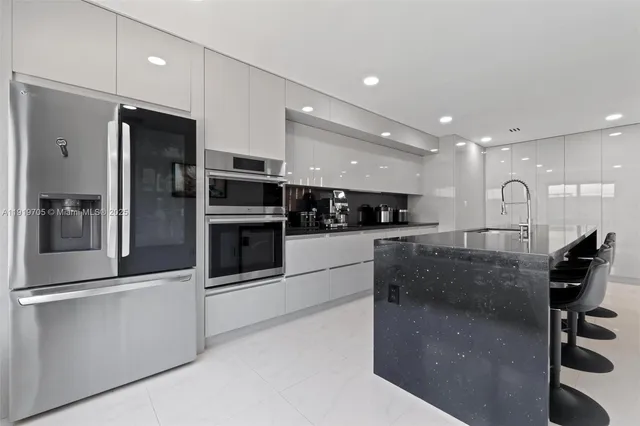 a kitchen with stainless steel appliances granite countertop a sink and white cabinets