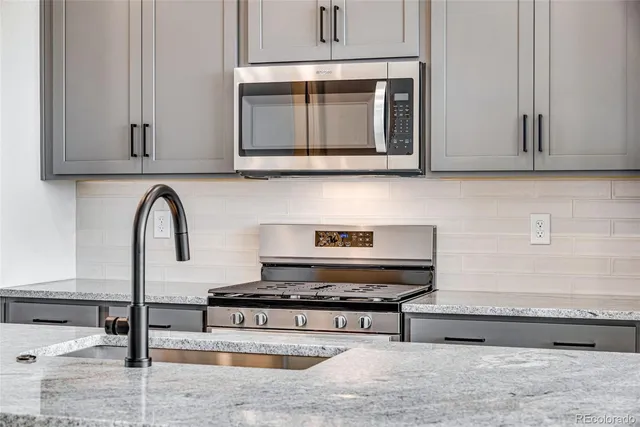 a kitchen with stainless steel appliances kitchen island a stove and a sink