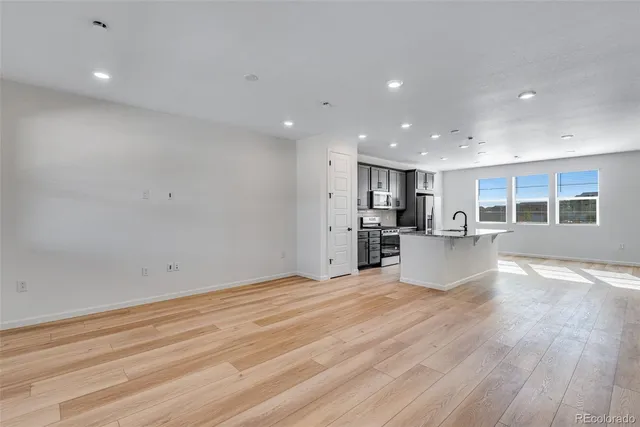 a view of empty room with wooden floor and windows