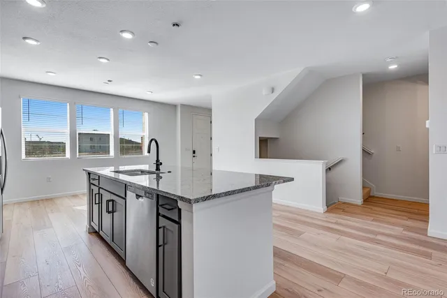 a kitchen with stainless steel appliances granite countertop a stove and a wooden floors