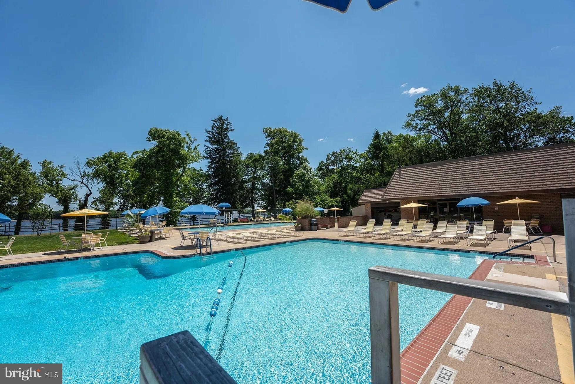 1101 Delaire Landing Road, Unit 101 Philadelphia, PA 19114 - Photo 27 of 29 Serene poolside retreat under clear skies.
