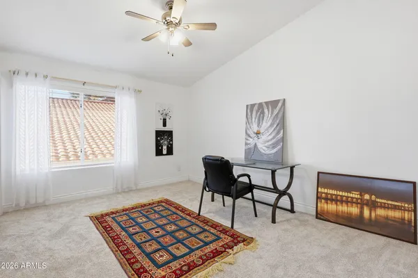 a view of a bedroom with furniture and a ceiling fan