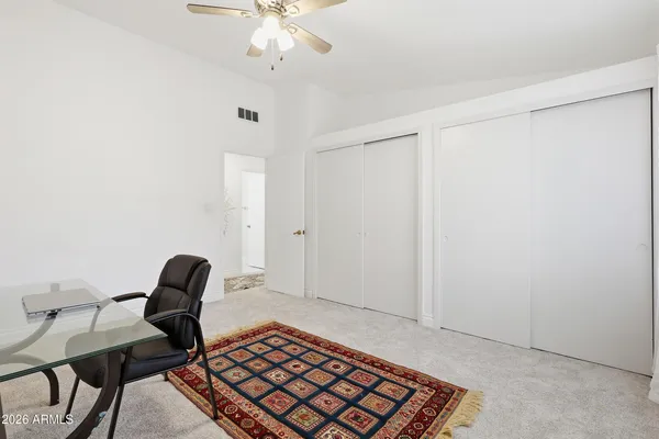 a bedroom with a bed and a table with potted plant