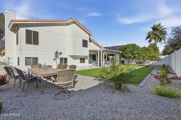 a backyard of a house with table and chairs