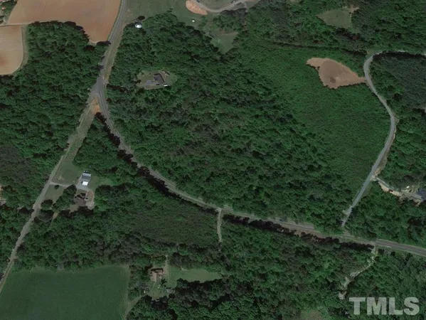 an aerial view of residential house with outdoor space and trees all around