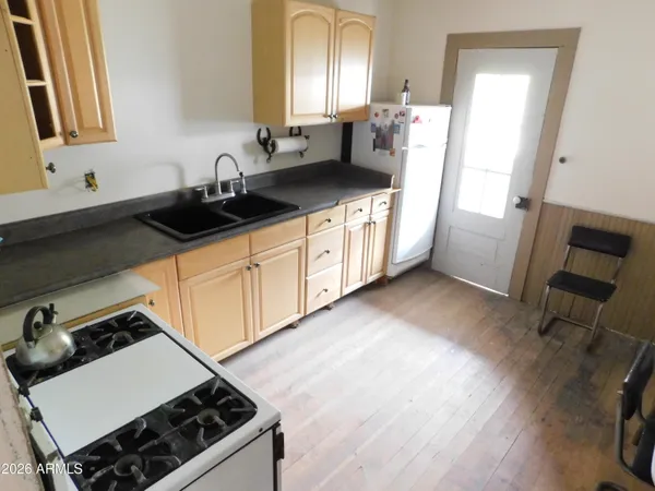 a kitchen with stainless steel appliances a sink a stove wooden floor and cabinets