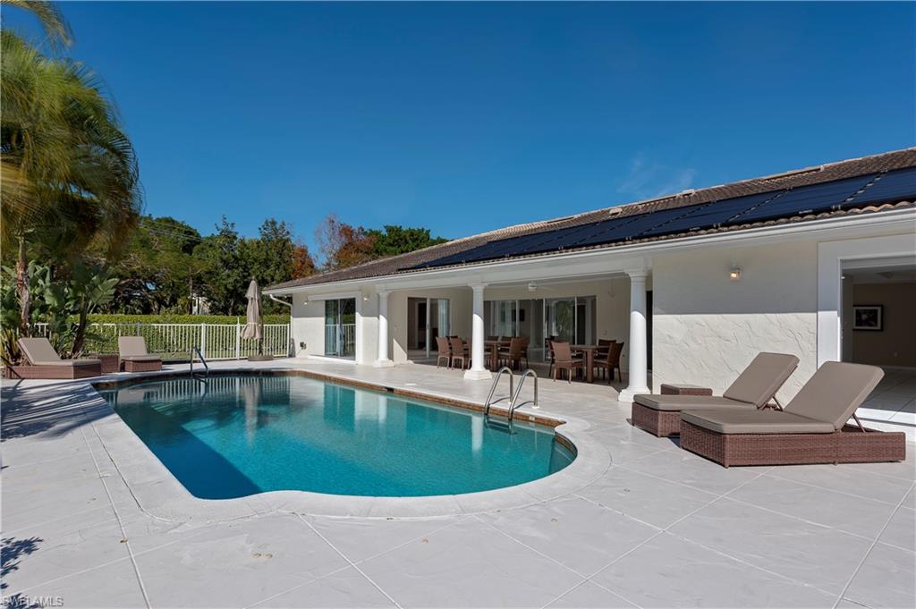 a view of a house with swimming pool and sitting area