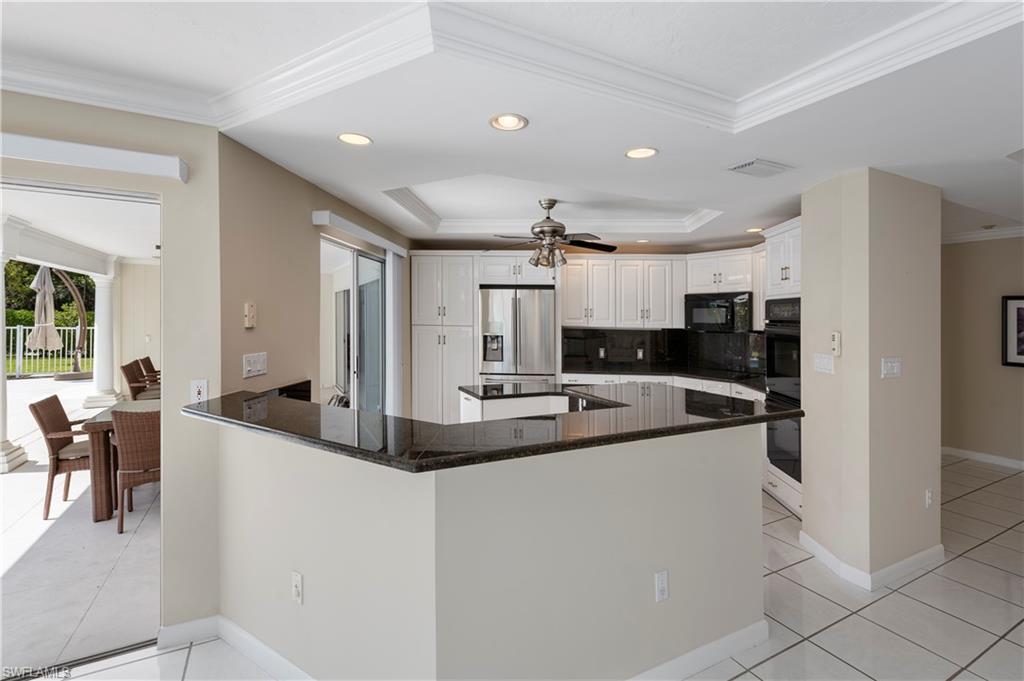 502 Whispering Pine Lane Naples, FL 34103 - Photo 6 of 11 a large kitchen with stainless steel appliances kitchen island a large counter top and a refrigerator