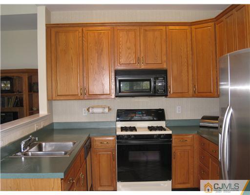 33 Brownstone Road East Windsor, NJ 08520 - Photo 4 of 20 a kitchen with granite countertop a stove a sink and a microwave