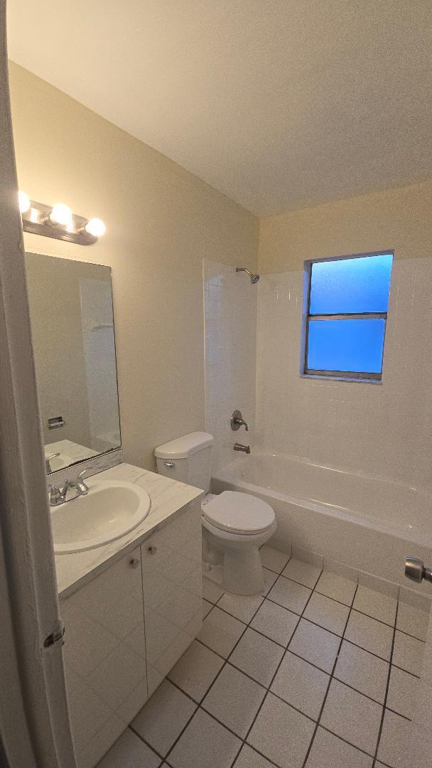 4403 Treehouse Lane, Unit H Tamarac, FL 33319 - Photo 11 of 26 a bathroom with a toilet sink and mirror