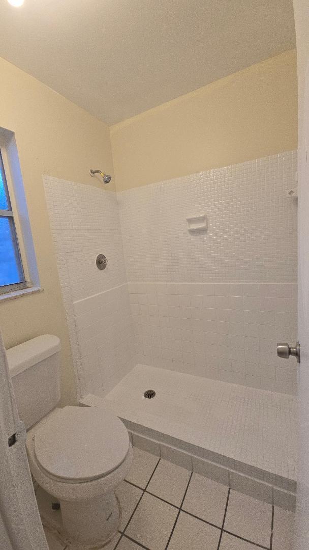 4403 Treehouse Lane, Unit H Tamarac, FL 33319 - Photo 17 of 26 a bathroom with a toilet and a shower