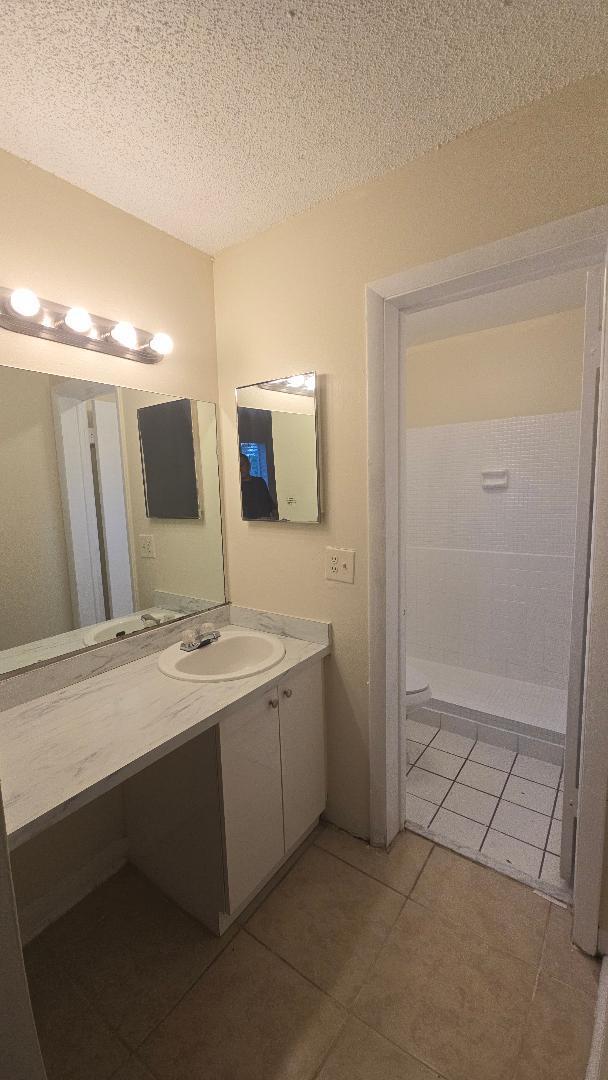 4403 Treehouse Lane, Unit H Tamarac, FL 33319 - Photo 18 of 26 a bathroom with a double vanity sink and mirror