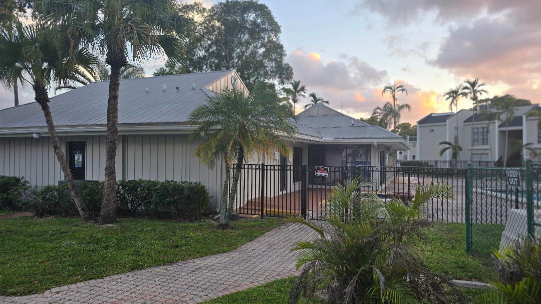 4403 Treehouse Lane, Unit H Tamarac, FL 33319 - Photo 21 of 26 a front view of a house with a garden and plants