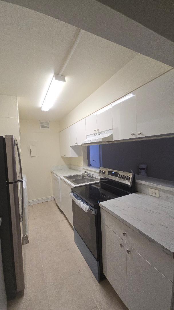 4403 Treehouse Lane, Unit H Tamarac, FL 33319 - Photo 4 of 26 a kitchen with stainless steel appliances granite countertop a stove and a refrigerator