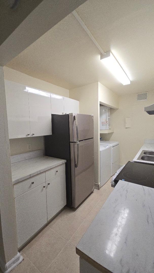 4403 Treehouse Lane, Unit H Tamarac, FL 33319 - Photo 5 of 26 a kitchen with a refrigerator and a sink