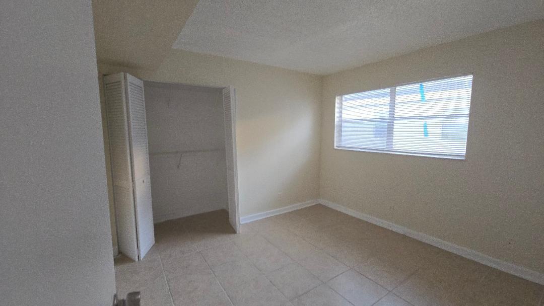 4403 Treehouse Lane, Unit H Tamarac, FL 33319 - Photo 9 of 26 an empty room with a window