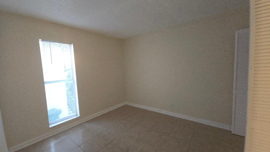 4403 Treehouse Lane, Unit H Tamarac, FL 33319 - Photo 10 of 26 an empty room with a window