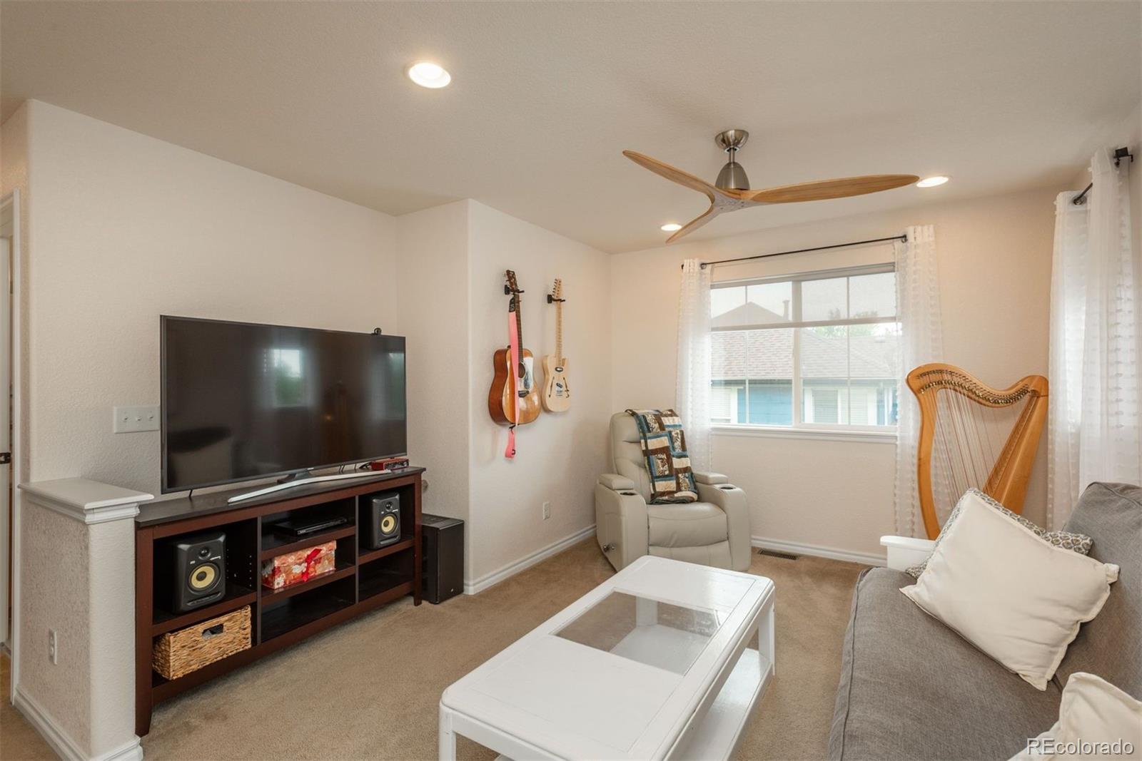 10696 Riverbrook Circle Highlands Ranch, CO 80126 - Photo 18 of 24 a living room with furniture and a flat screen tv