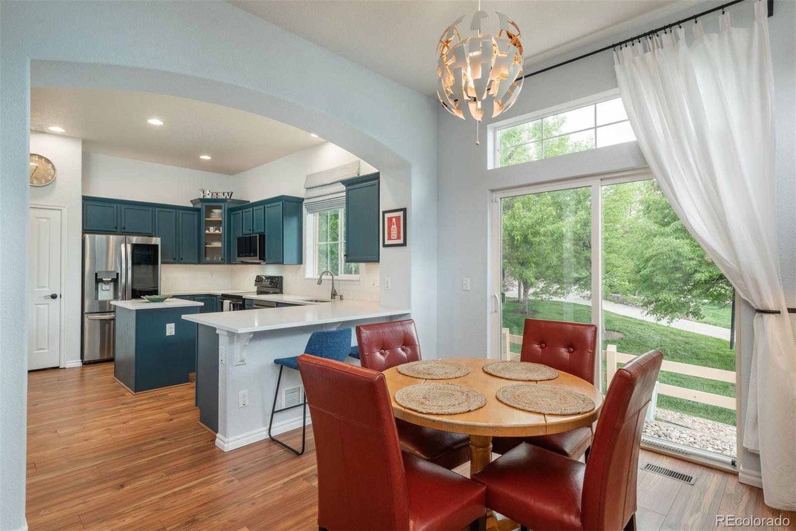 10696 Riverbrook Circle Highlands Ranch, CO 80126 - Photo 4 of 24 a dining room with stainless steel appliances granite countertop a dining table chairs and a refrigerator