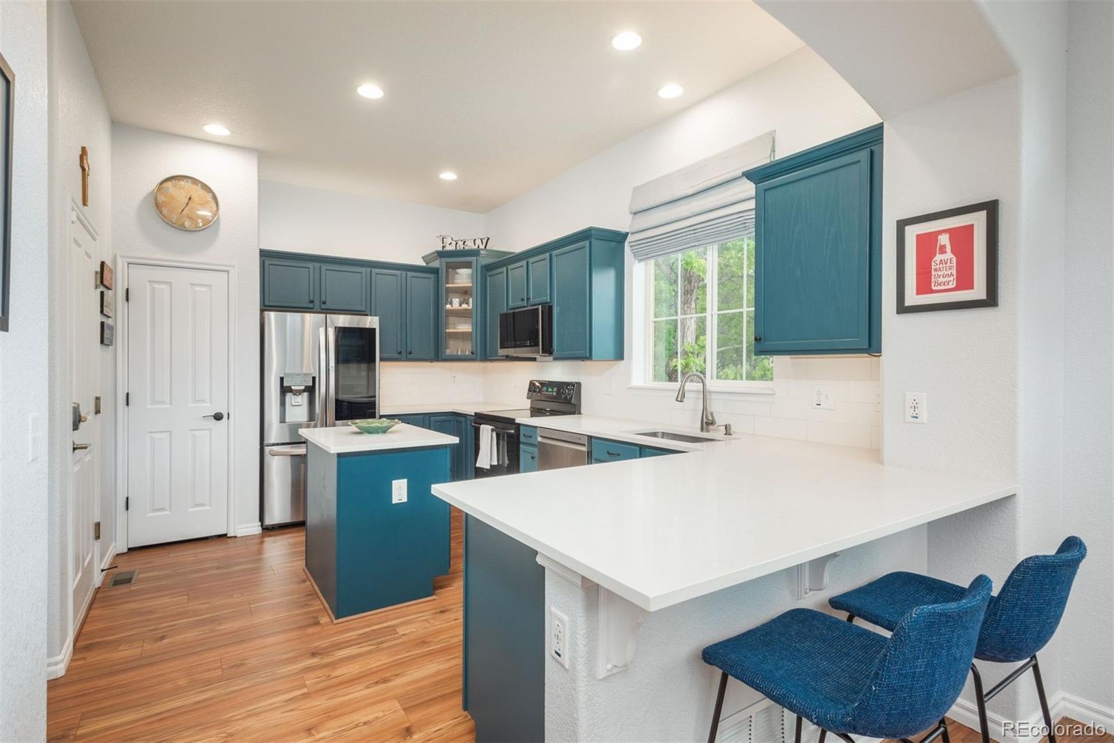 10696 Riverbrook Circle Highlands Ranch, CO 80126 - Photo 5 of 24 a kitchen with stainless steel appliances a sink a stove a refrigerator cabinets and a dining table