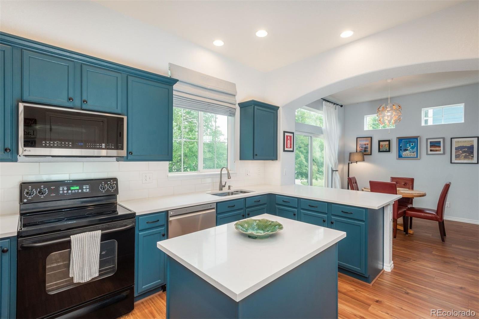 10696 Riverbrook Circle Highlands Ranch, CO 80126 - Photo 7 of 24 a kitchen with a stove a sink and a microwave