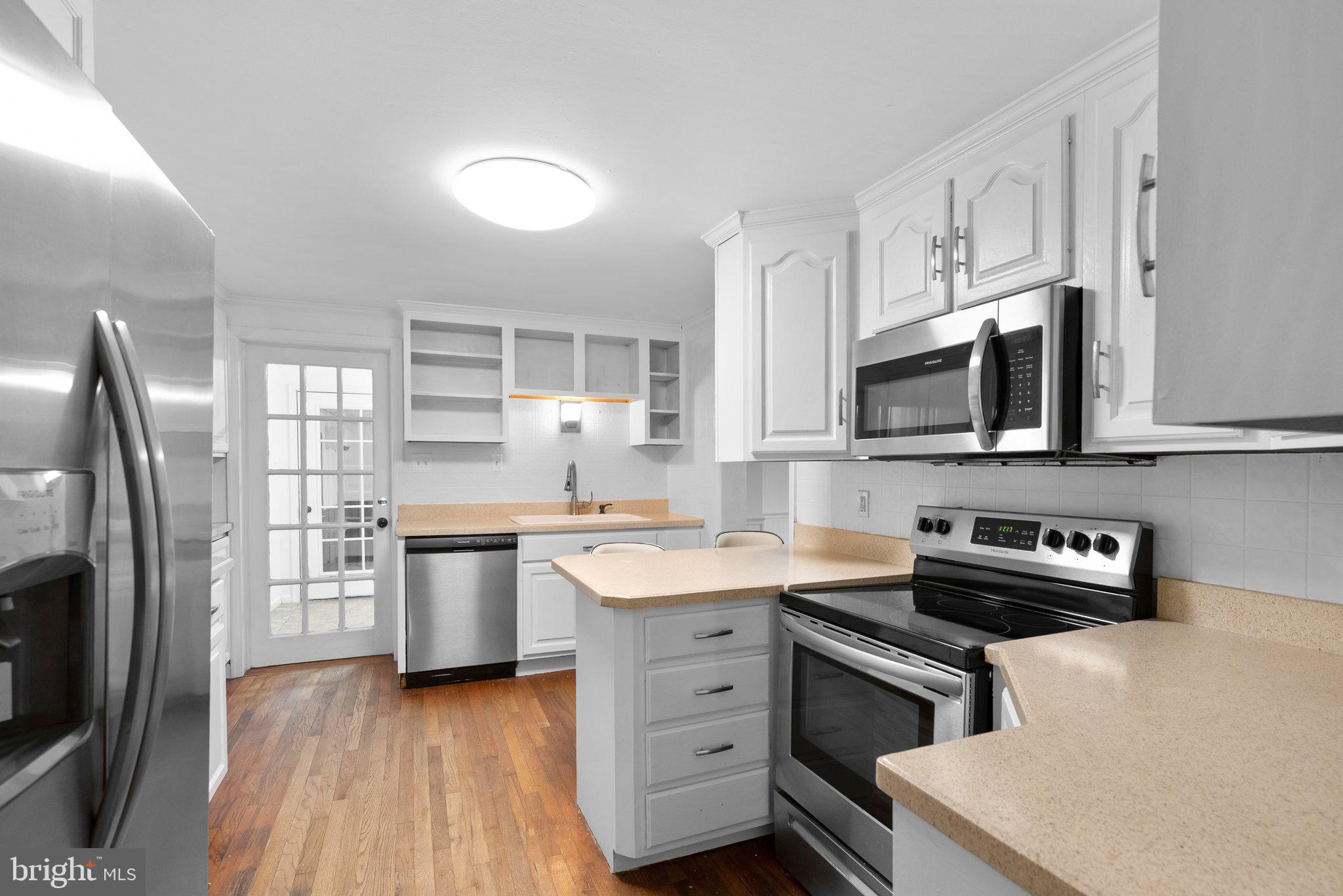 a kitchen with stainless steel appliances a stove sink microwave and cabinets
