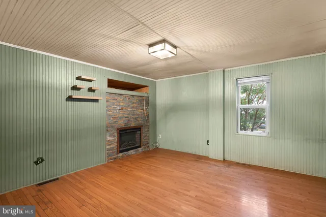a view of empty room with window and fireplace