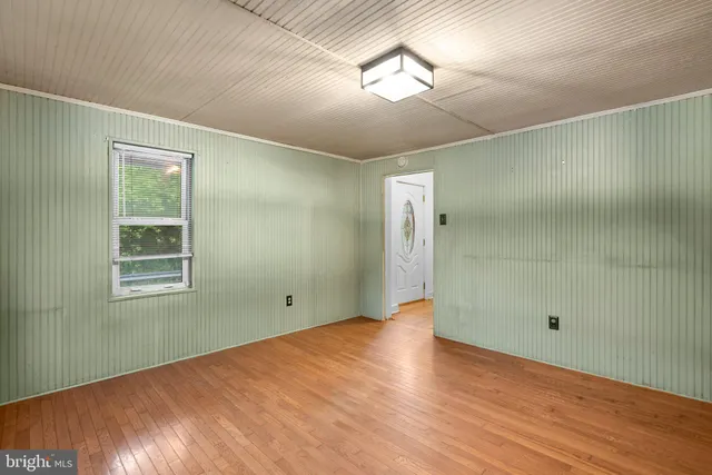 a view of empty room with wooden floor