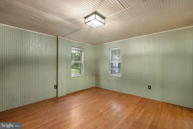 a view of empty room with wooden floor