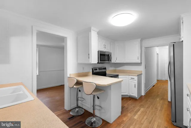 a kitchen with a sink a counter top space and stainless steel appliances