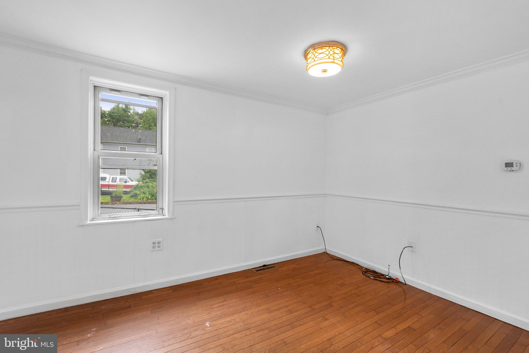 810 Knoxville Road Knoxville, MD 21758 - Photo 22 of 42 a view of an empty room with window and wooden floor