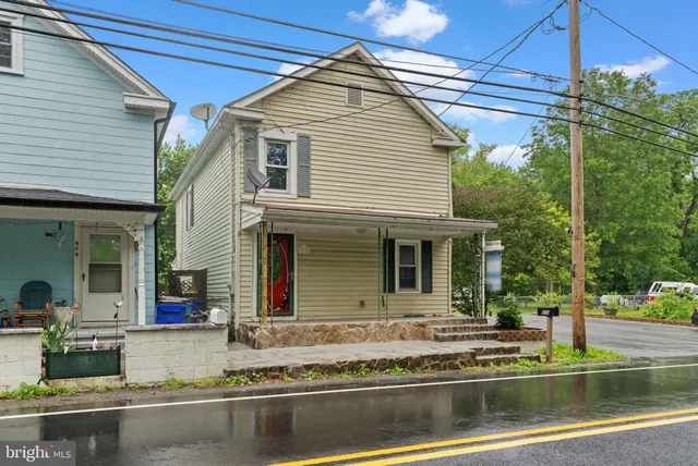 a view of a white house with large windows and a table